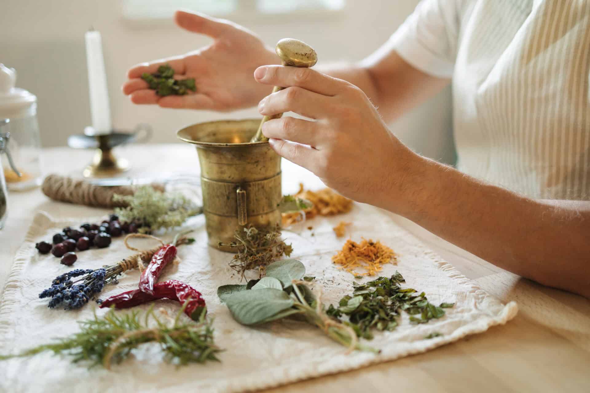 Man adds dried mint to a mortar and pestle. Homemade healthy and nutrition supplements. High quality photo